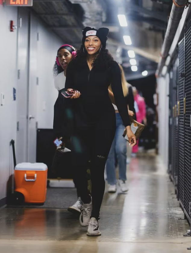 Betnijah Laney-Hamilton proved that black is always…the new black as she rocked a full black ensemble paired with muted gray Yeezy Boost 350 V2 sneakers for the New York Liberty’s first away game of the season. However, she wasn’t all business, adding a pair of hoop earrings, a cat-ear hat, and bright lipstick to make the outfit both fun and sleek at the same time. 