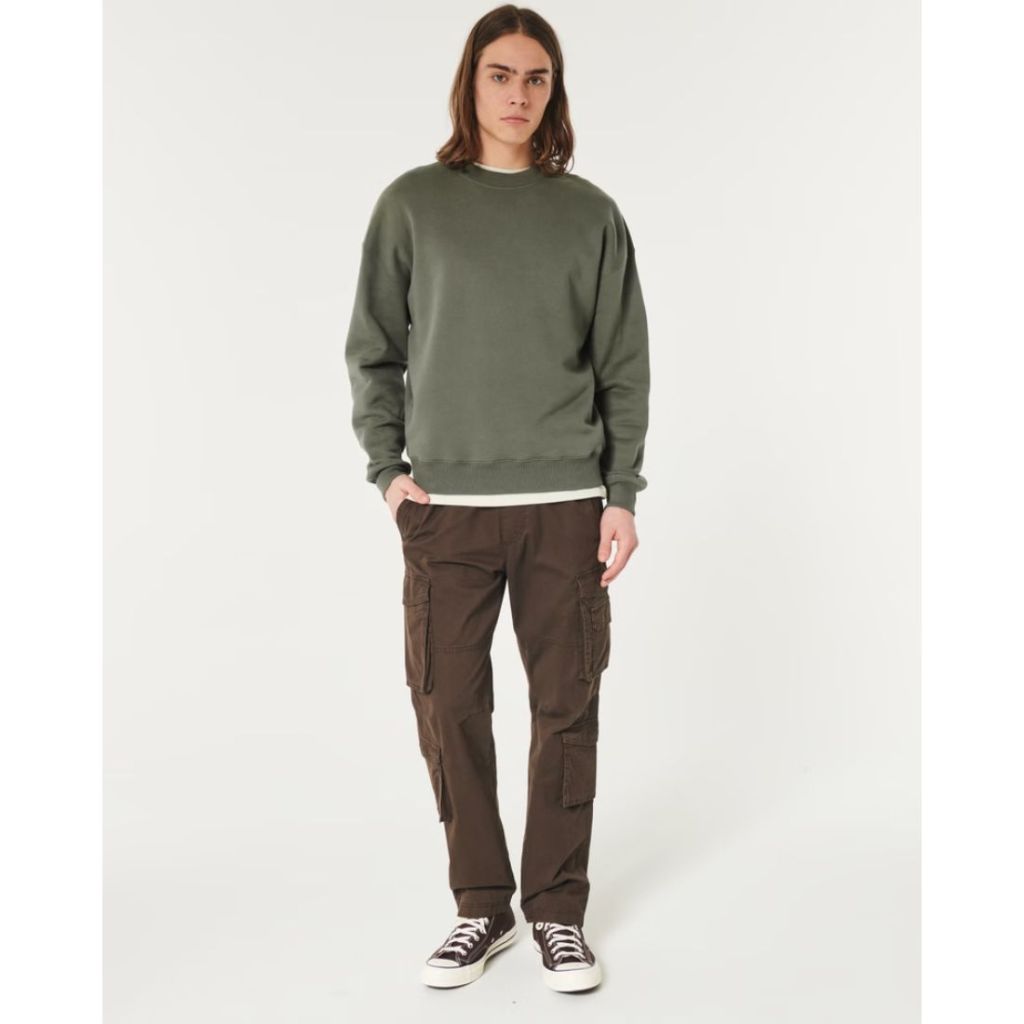 model wearing dark green hollister crewneck with brown cargo pants