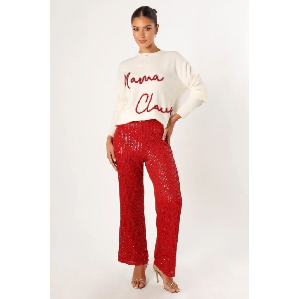 model wearing red sequin pants and white sweater