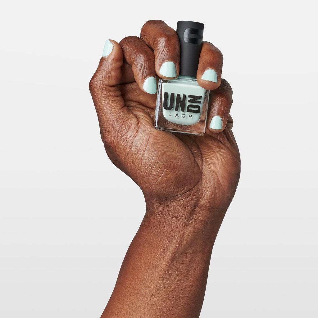 model wearing teal nail polish and holding bottle